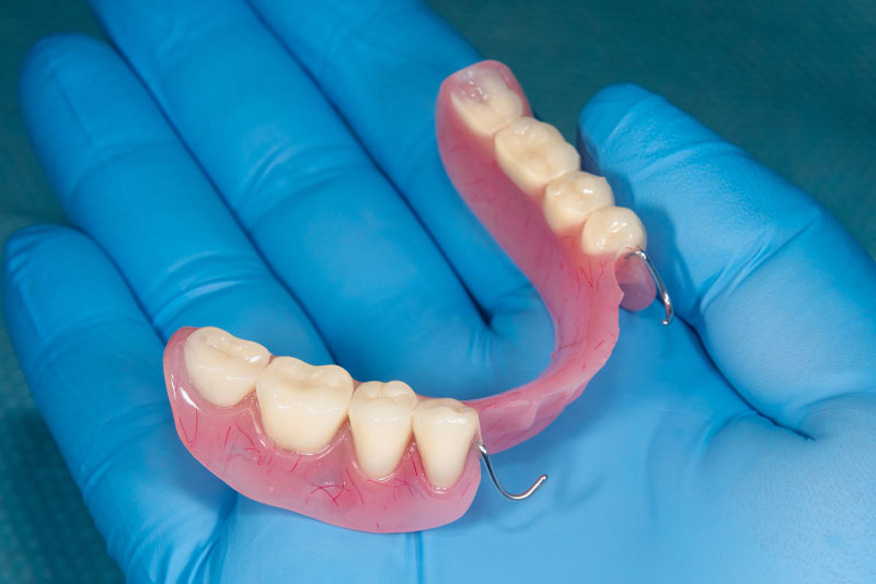Doctor Holding Partial Dentures