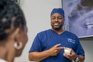 Dr. Marlon Moore Educating A Dental Patient About Dental Implants