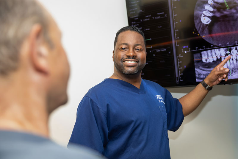 Dr Marlon Moore Showing A Dental Patient Their Oral CT Scan