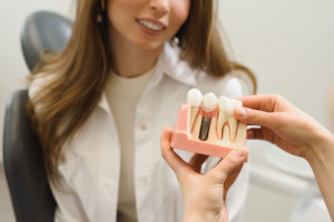 Dental Patient Getting Shown A Dental Implant Model During Her Consultation in Bronx, NY