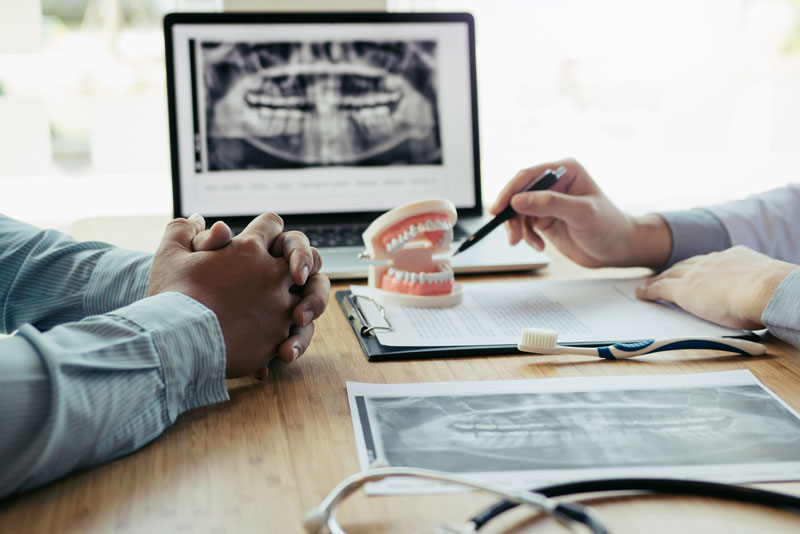 a dental implant dentist and a patient discuss dental implant surgery.